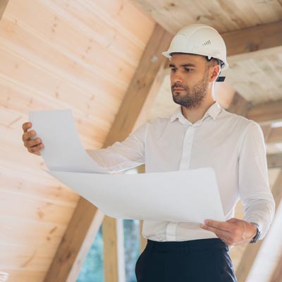 Mann mit weißem Helm liest Bauplan für Baubegleitung und Projektmanagement am Bau Hamburg